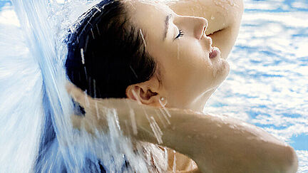 Nackendusche Frau unter einer Nackendusche