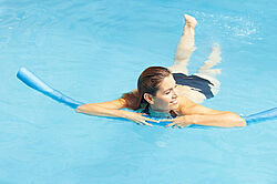 Frau mit Poolnudel im Wasser Frau mit Poolnudel im Wasser