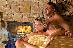 Paar vor dem Kamin in der Maa-Sauna Paar vor dem Kamin in der Maa-Sauna